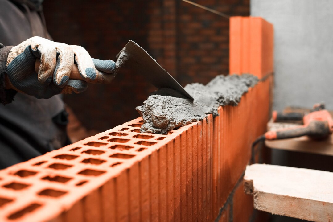 bricklayer-puts-bricks-make-wall_153608-1196
