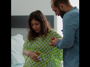 african-american-nurse-helping-pregnant-wife-sit-wheelchair-maternity-ward-hospital-young-caucasian-mother-preparing-childbirth-medical-assistance-with-father-baby